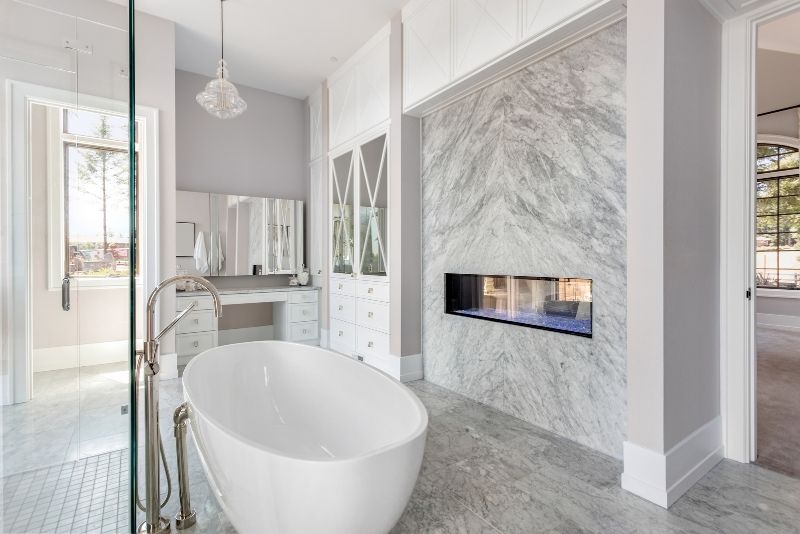 spacious bathroom area with white coloured wall and bath tub